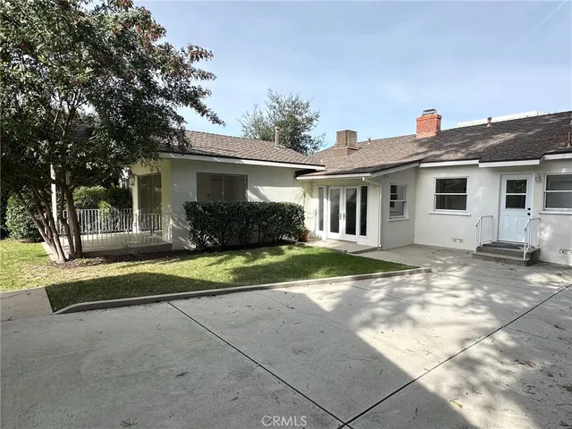 a view of a house with backyard and trees