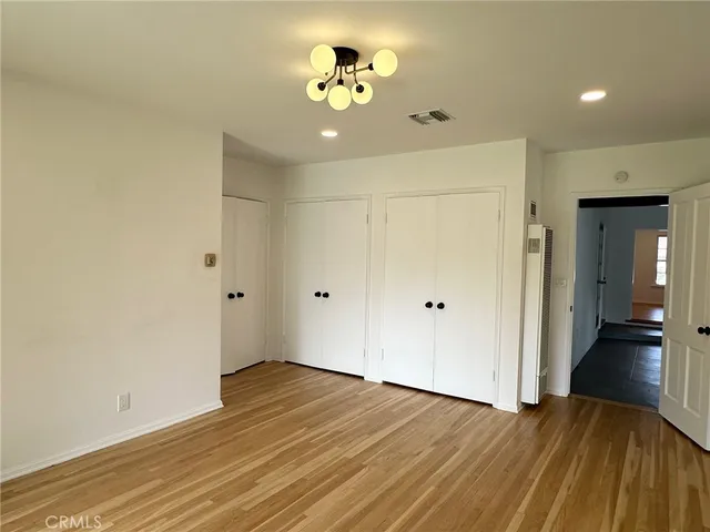 a view of a room with wooden floor and a ceiling fan