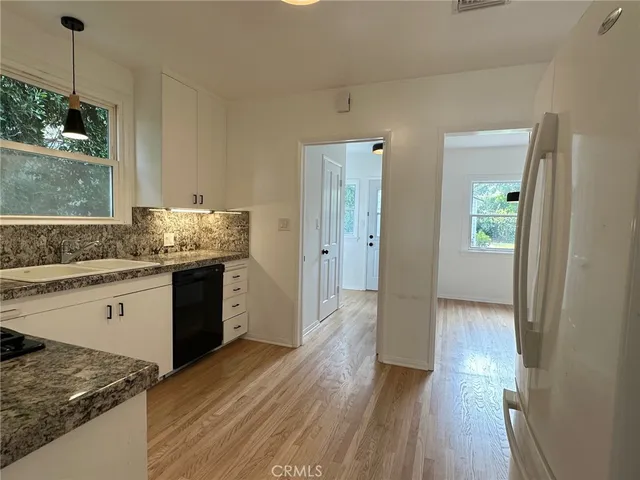 a kitchen with a sink and wooden floor