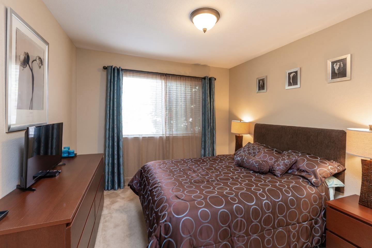 6593 Springpath Lane San Jose, CA 95120 - Photo 14 of 40 a bedroom with a large bed and a flat tv screen on dresser