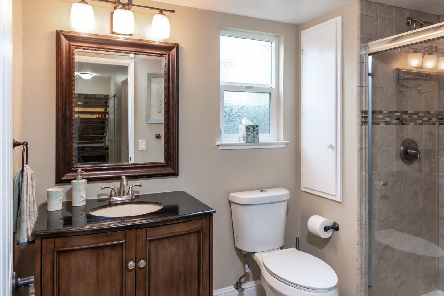 6593 Springpath Lane San Jose, CA 95120 - Photo 15 of 40 a bathroom with a granite countertop toilet a sink a mirror and a shower
