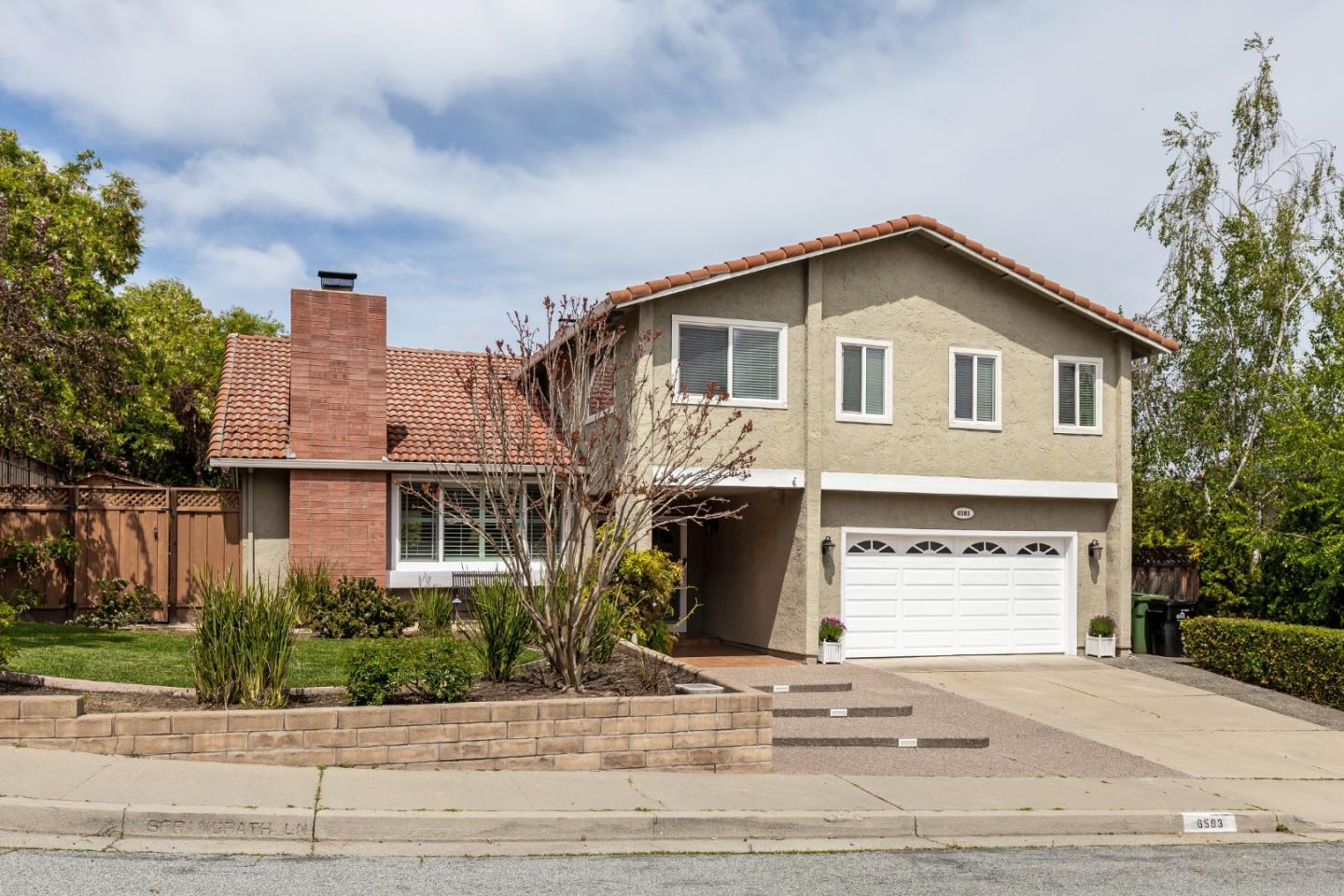 6593 Springpath Lane San Jose, CA 95120 - Photo 4 of 40 a front view of a house with a yard and garage