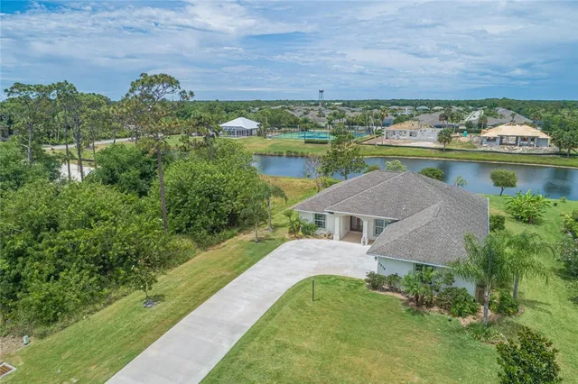 an aerial view of a house with a garden and lake view
