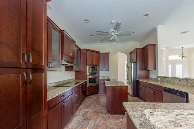 a large kitchen with stainless steel appliances granite countertop a sink a stove and a refrigerator