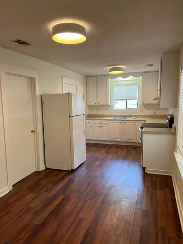 a kitchen with a refrigerator and a stove top oven