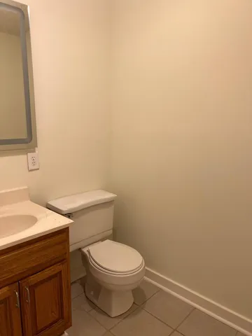 a white toilet sitting next to a white sink and vanity