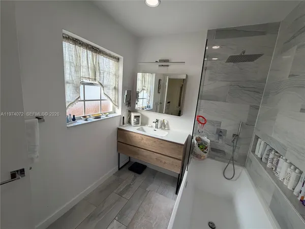 a bathroom with a tub sink toilet and mirror