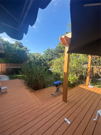 a backyard of a house with wooden floor and outdoor seating