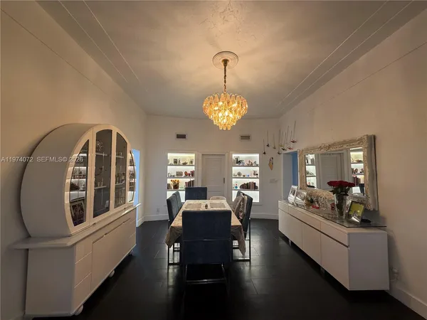 a very nice looking dining room with furniture a chandelier and wooden floor