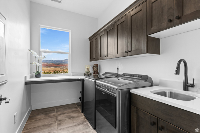 3022 West Sesia Way St. George, UT 84770 - Photo 29 of 52 Laundry room with cabinet space, washing machine and clothes dryer, and light tile patterned floors