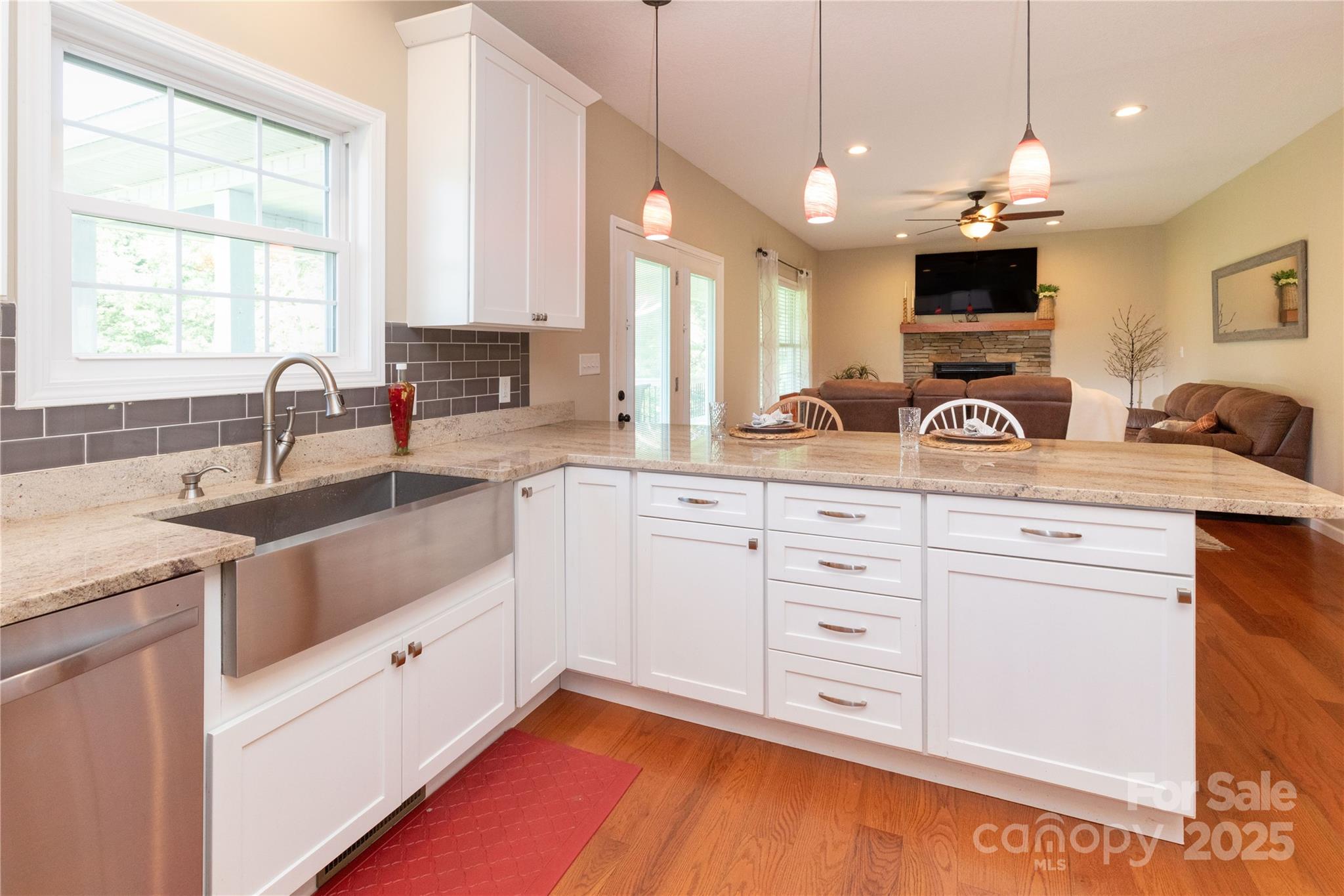 460 Panther Branch Road Alexander, NC 28701 - Photo 16 of 32 a kitchen with kitchen island granite countertop a sink window and white cabinets
