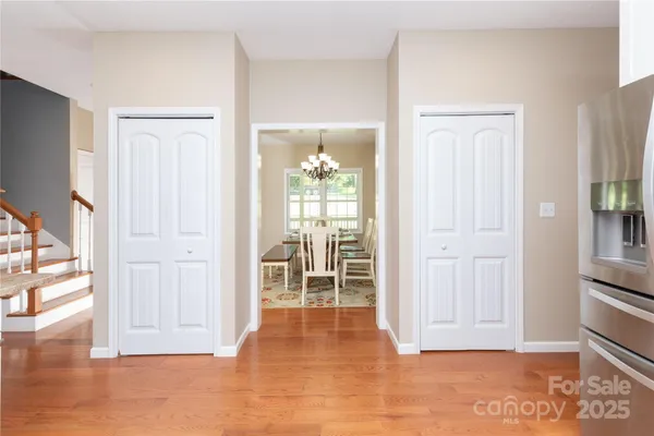 a view of a hallway with wooden floor and a cabinet