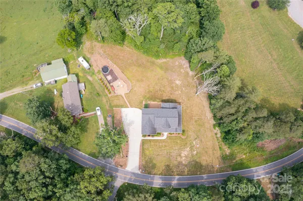 an aerial view of a house with a yard and trees