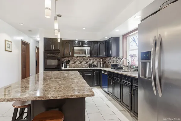 a kitchen with kitchen island a counter top space appliances and cabinets