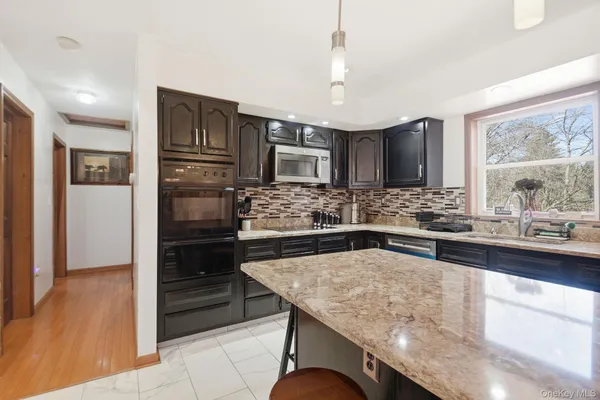 a kitchen with stainless steel appliances granite countertop a sink and a refrigerator