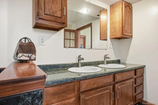 a bathroom with a granite countertop sink and a mirror