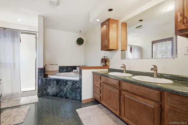 a spacious bathroom with a granite countertop sink and a mirror