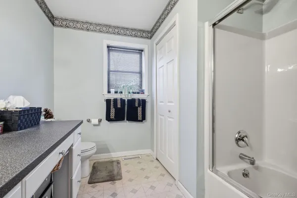 a bathroom with a granite countertop sink a toilet and bathtub