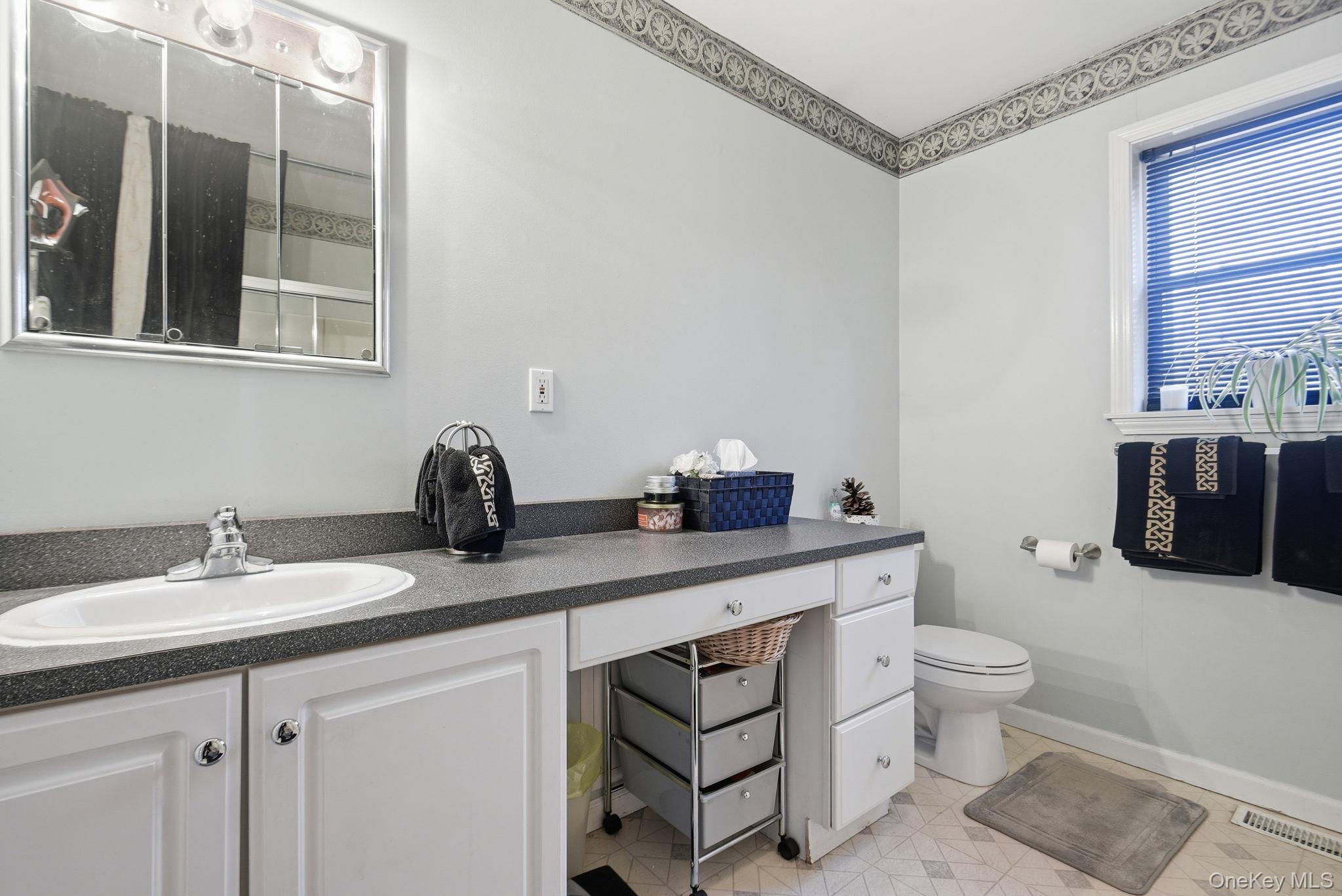 25 De Garmo Road Poughkeepsie, NY 12603 - Photo 35 of 50 a spacious bathroom with a granite countertop sink a toilet and a mirror