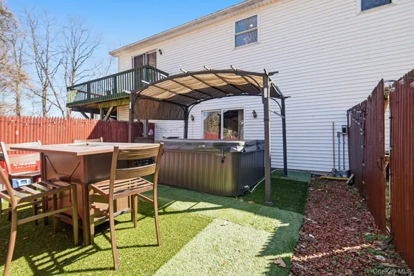 a view of a patio with table and chairs with wooden fence