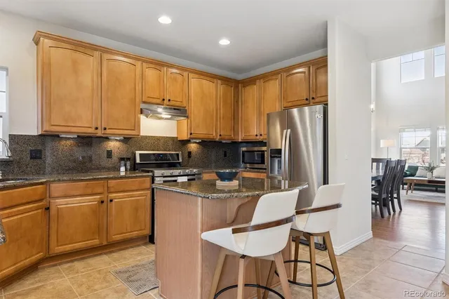 a kitchen with refrigerator cabinets dining table and chairs
