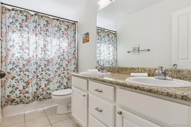 a bathroom with a granite countertop sink a toilet and a mirror