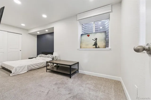 a spacious bedroom with a bed and a painting on the wall