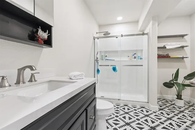 a bathroom with a sink a toilet and shower