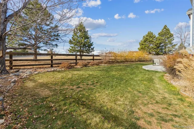 a view of a yard with wooden fence