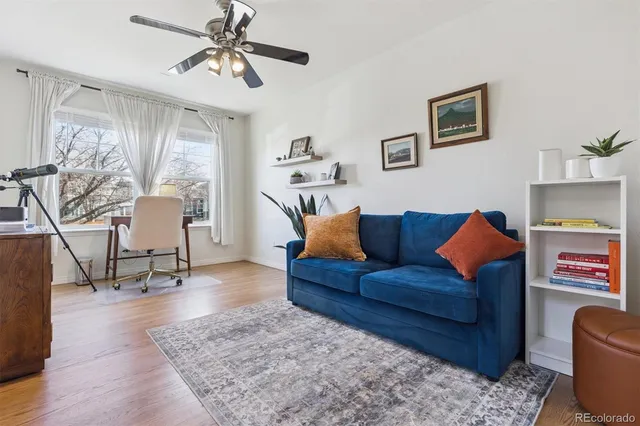 a living room with furniture and a dining table with wooden floor
