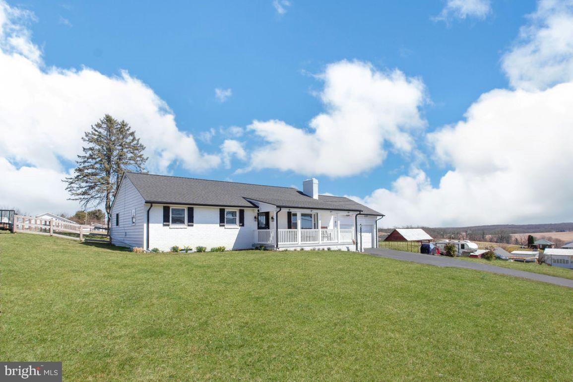 a view of a house with a big yard and large trees