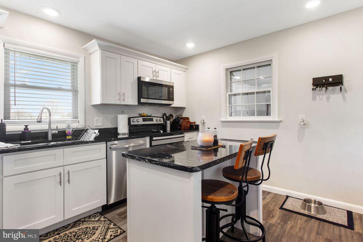 2970 Baltimore Pike Hanover, PA 17331 - Photo 11 of 30 a kitchen with stainless steel appliances granite countertop a stove a sink dishwasher a microwave refrigerator and cabinets with wooden floor
