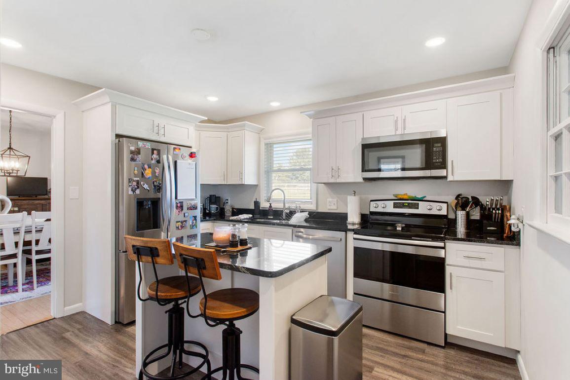 2970 Baltimore Pike Hanover, PA 17331 - Photo 12 of 30 a kitchen with stainless steel appliances granite countertop a stove top oven a sink dishwasher and a refrigerator with wooden floor