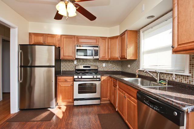 557 Sumac Road Highland Park, IL 60035 - Photo 2 of 20 a kitchen with stainless steel appliances granite countertop a refrigerator a stove a sink and a microwave