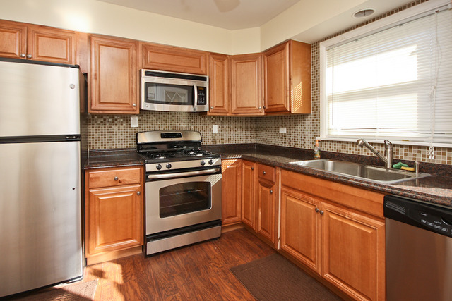 557 Sumac Road Highland Park, IL 60035 - Photo 3 of 20 a kitchen with granite countertop a refrigerator stove and microwave