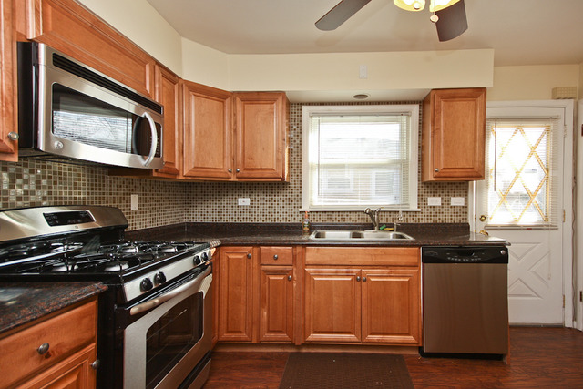 557 Sumac Road Highland Park, IL 60035 - Photo 4 of 20 a kitchen with granite countertop wooden cabinets and a stove top oven