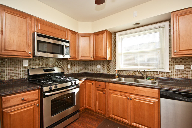 557 Sumac Road Highland Park, IL 60035 - Photo 5 of 20 a kitchen with stainless steel appliances a stove sink microwave and cabinets