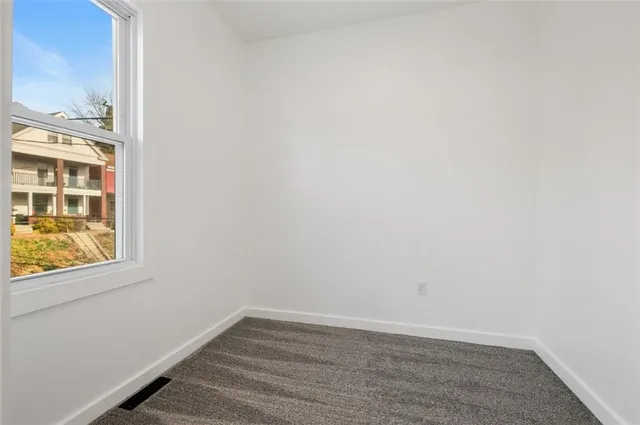 an empty room with wall closet and windows