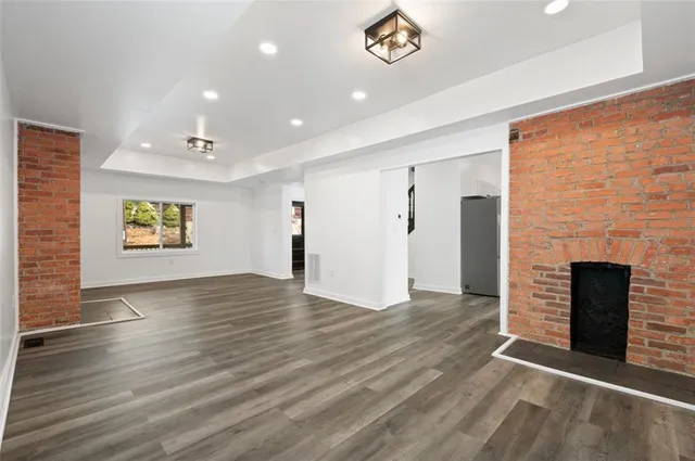an empty room with wooden floor and a fireplace