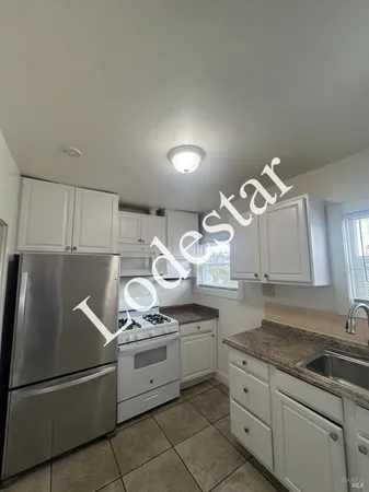 a kitchen with stainless steel appliances granite countertop a sink and a refrigerator
