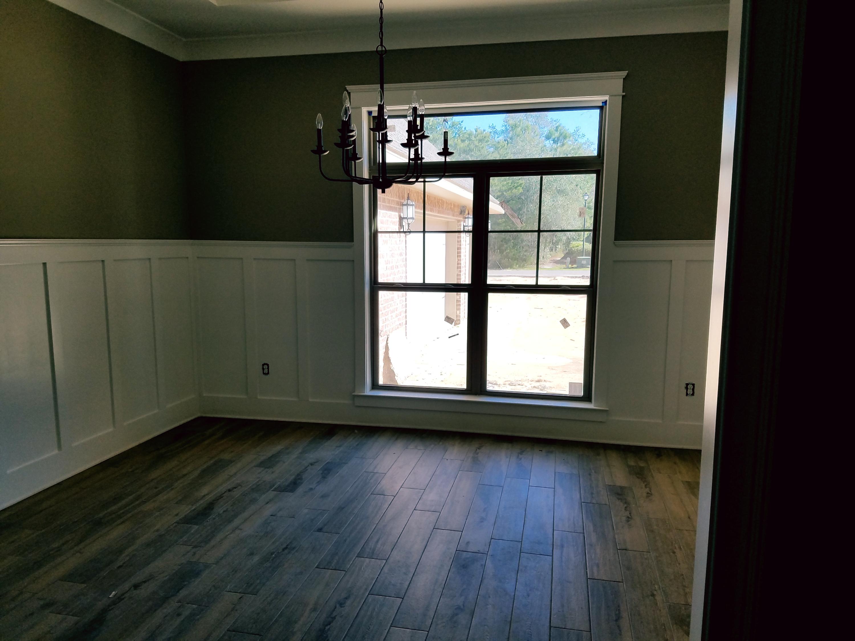 2585 Cove Road Navarre, FL 32566 - Photo 19 of 47 a view of an empty room with wooden floor and a window