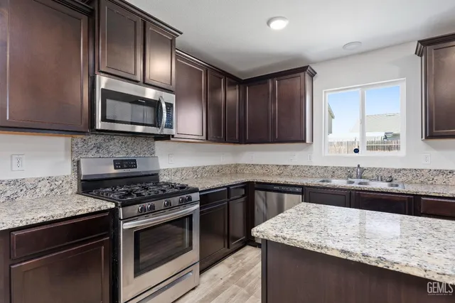 a kitchen with granite countertop a sink and a window