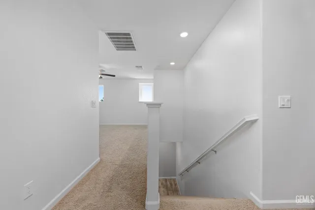 an empty room with a window and a ceiling fan