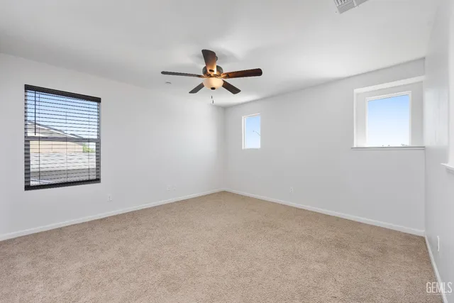 an empty room with windows and fan