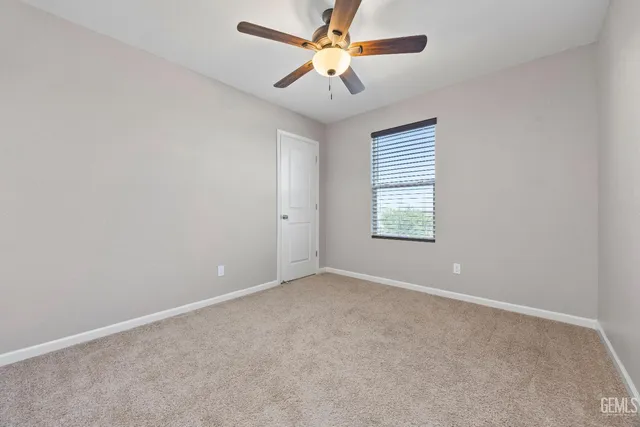 an empty room and chandelier fan in a room