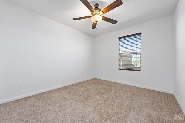 an empty room with closet and a chandelier fan