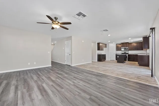 a large white kitchen with kitchen island a sink stainless steel appliances and cabinets