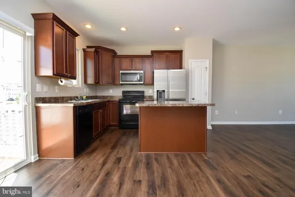 a kitchen with stainless steel appliances granite countertop a stove top oven a sink dishwasher and a refrigerator