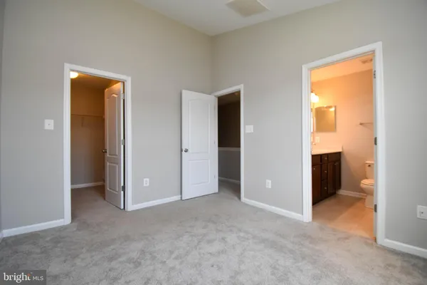 an empty room with closet and a bathroom