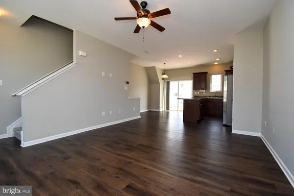 a view of a kitchen and a stove wooden floor a ceiling fan